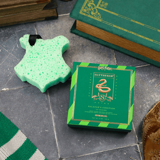 a green box with a green and gold design next to a green book