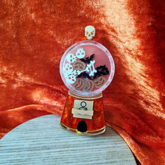 a small plastic object with a skull and bats inside