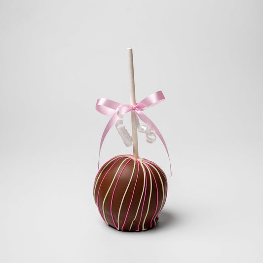a chocolate covered apple with a pink ribbon
