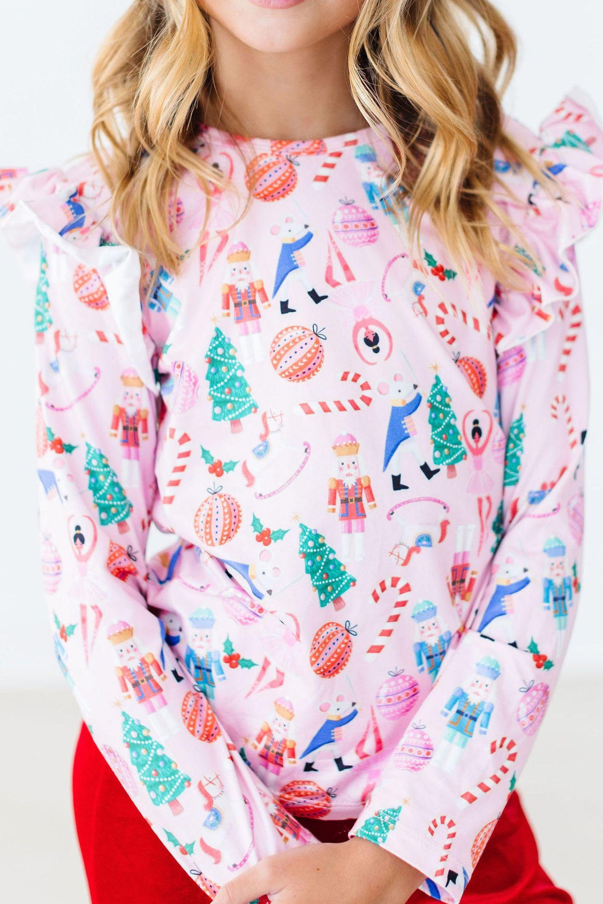 a girl wearing a pink shirt with christmas designs