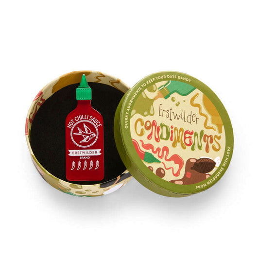 a small red bottle in a round box