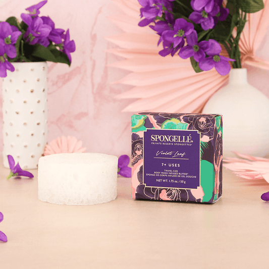 a box of soap next to a sponge and flowers