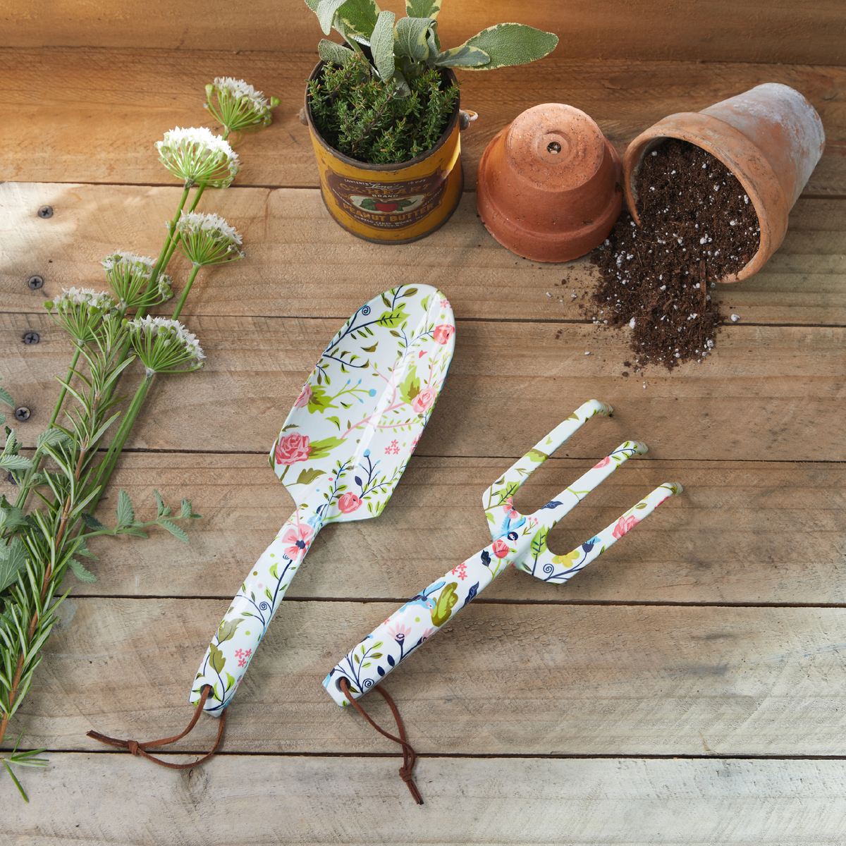a plant and a pot with soil next to a shovel and a shovel