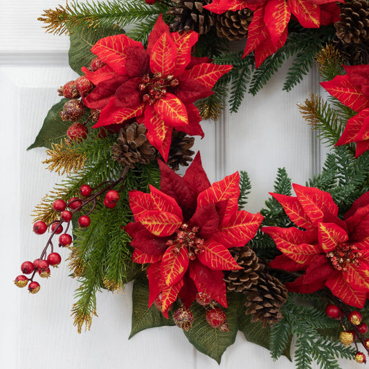 a wreath with red flowers and pine cones