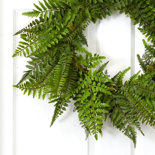 a green fern wreath on a white door