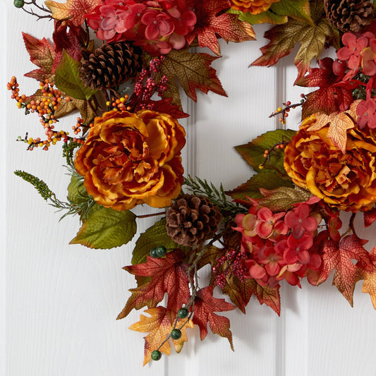 a wreath with flowers and leaves on a door
