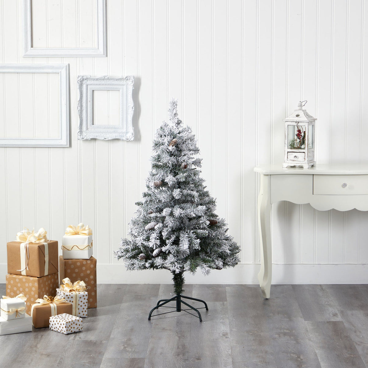 a christmas tree with presents in front of a white wall