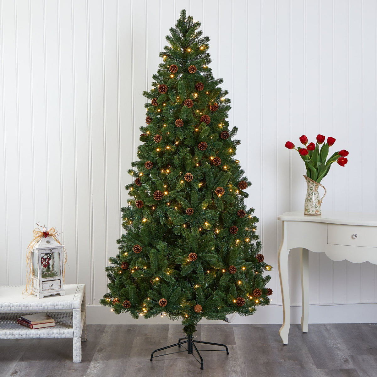 a christmas tree with lights and flowers in a room