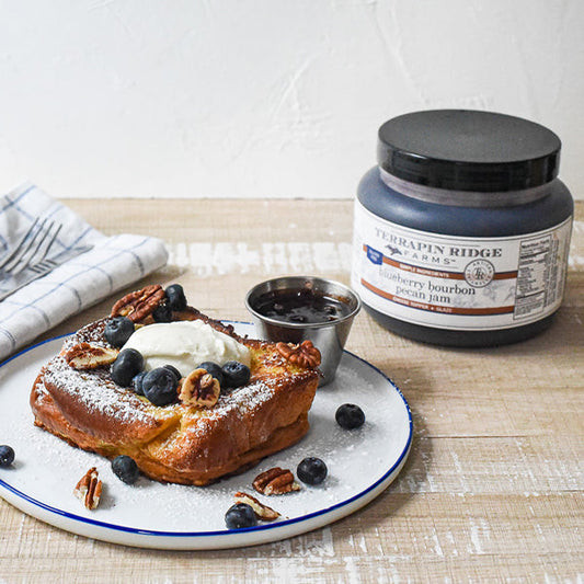 a plate of food with a jar of jam and a napkin