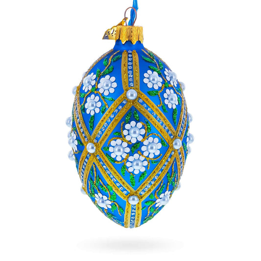 a blue decorated egg with white flowers and pearls