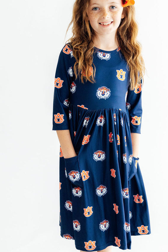 a woman in a blue dress with orange and white logos