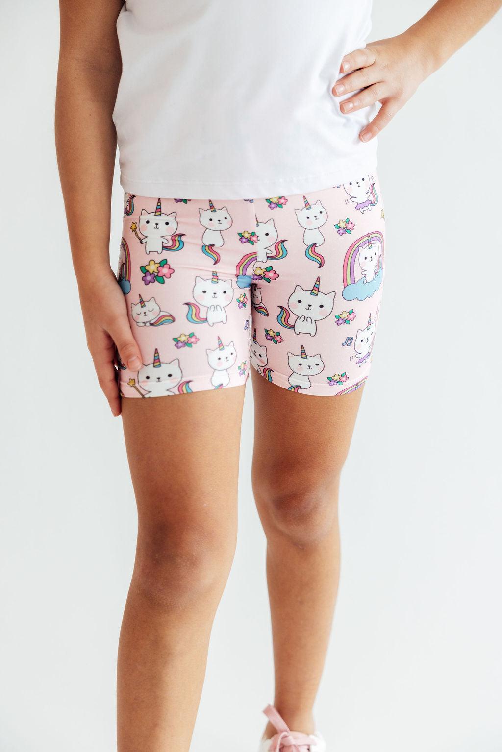 a person wearing pink shorts with cats and unicorns