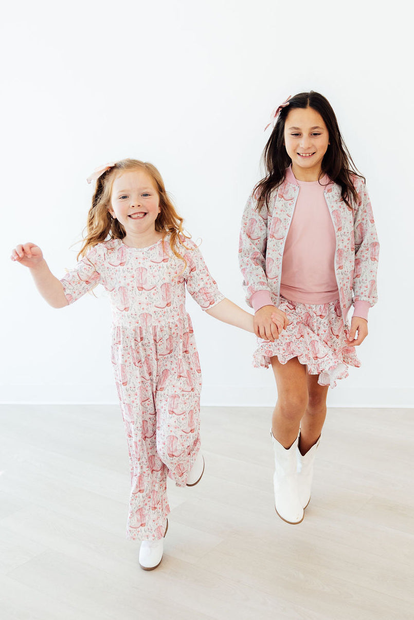 two girls holding hands and walking