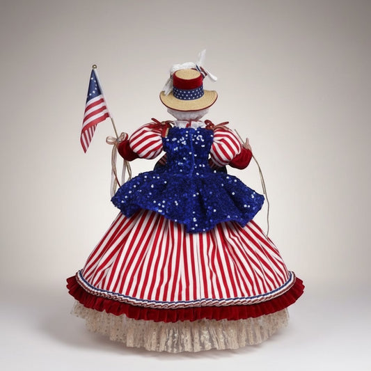 The Merry Hare Betsy Ross figurine in a red, white, and blue striped dress holding an American flag.