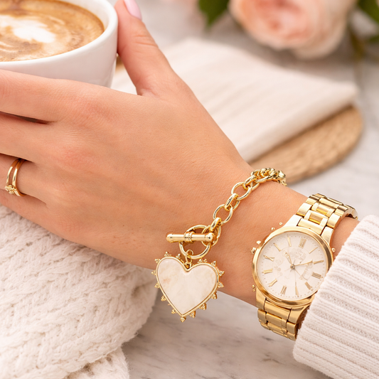 a woman's hand with a gold watch and a gold bracelet