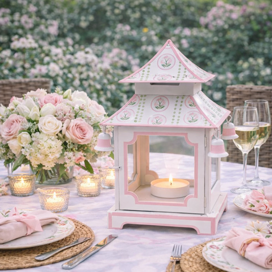 a table set with a candle holder and flowers