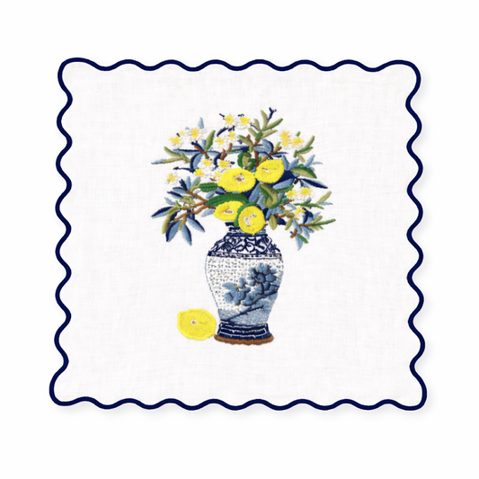 a vase with flowers and lemons