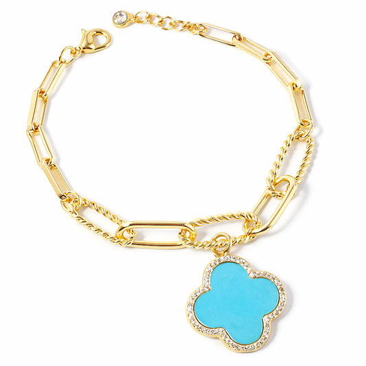 a gold chain bracelet with a blue flower pendant