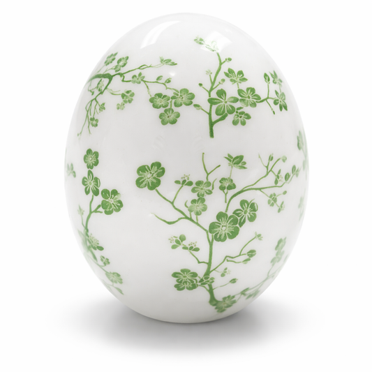 a white egg with green flowers on it