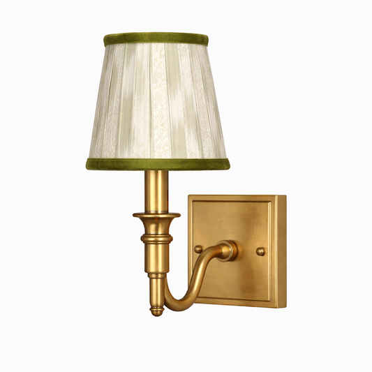 a gold wall lamp with a green shade