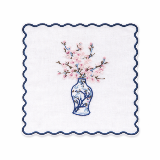 a white napkin with a vase of flowers