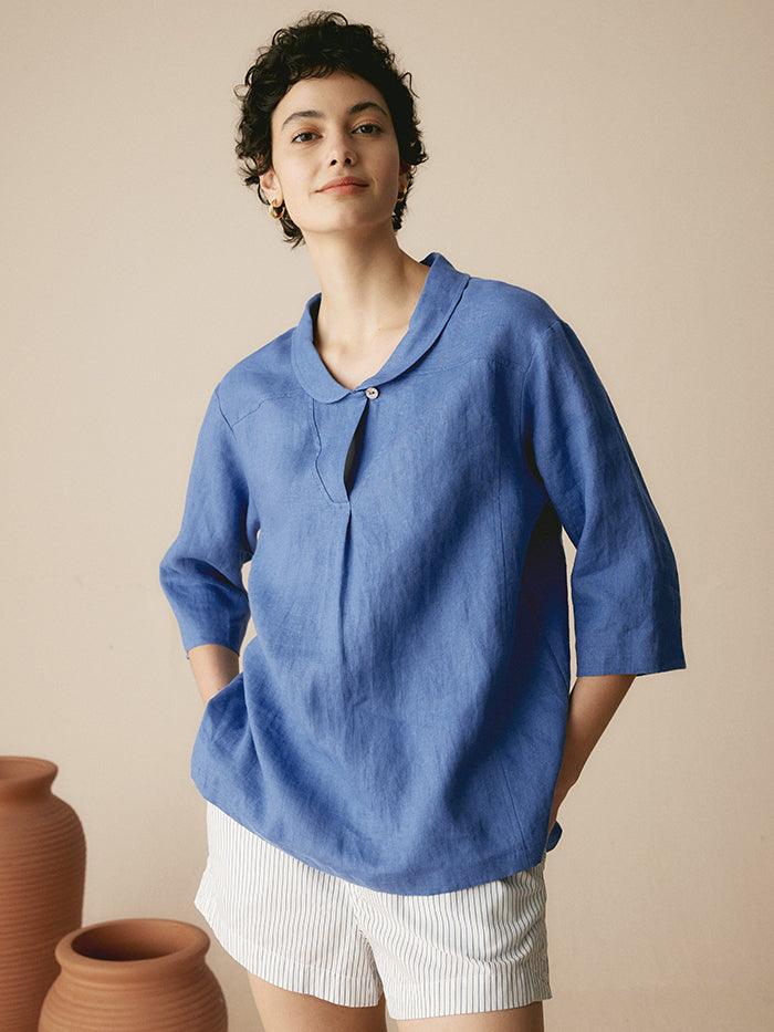 a woman in blue shirt and white pants