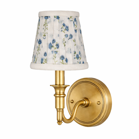 a gold wall light with a white and blue shade