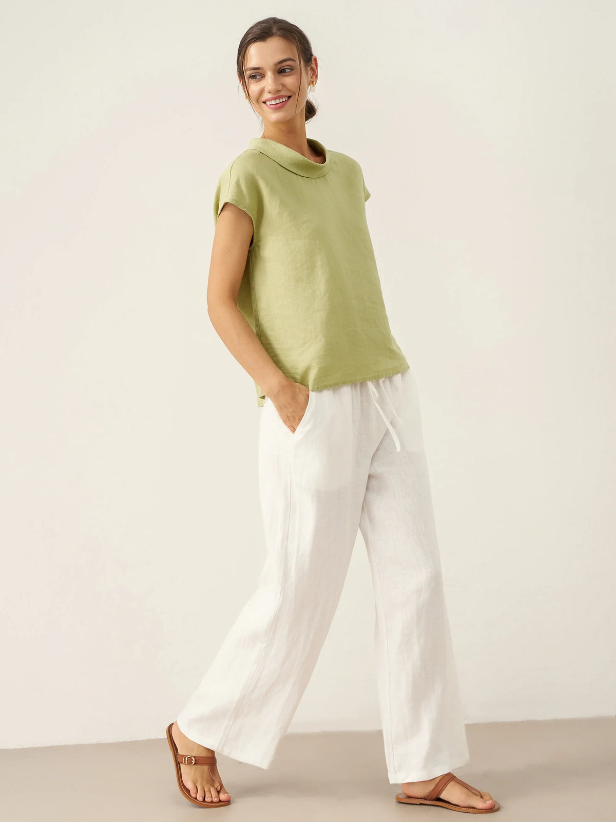 a woman in white pants and green shirt