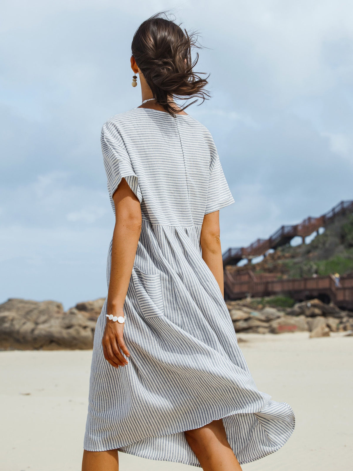 a woman in a dress walking on a beach