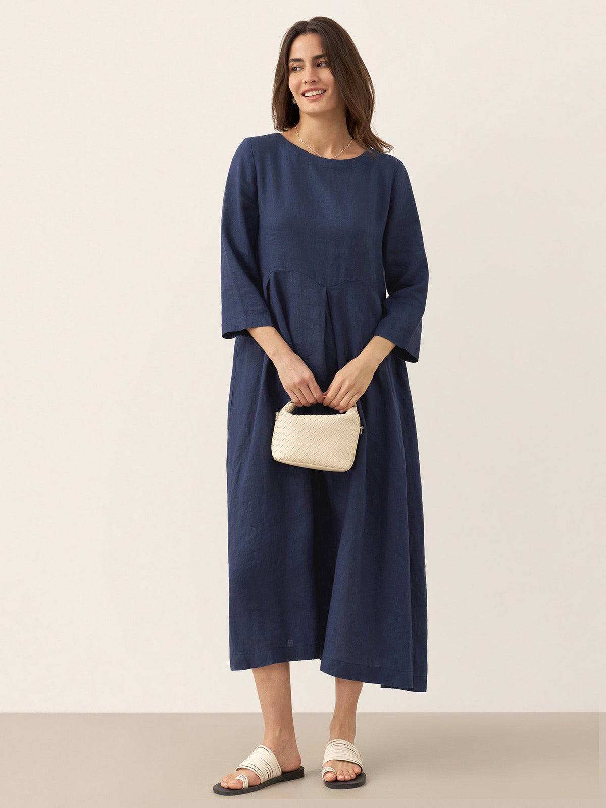 a woman in a blue dress holding a small purse