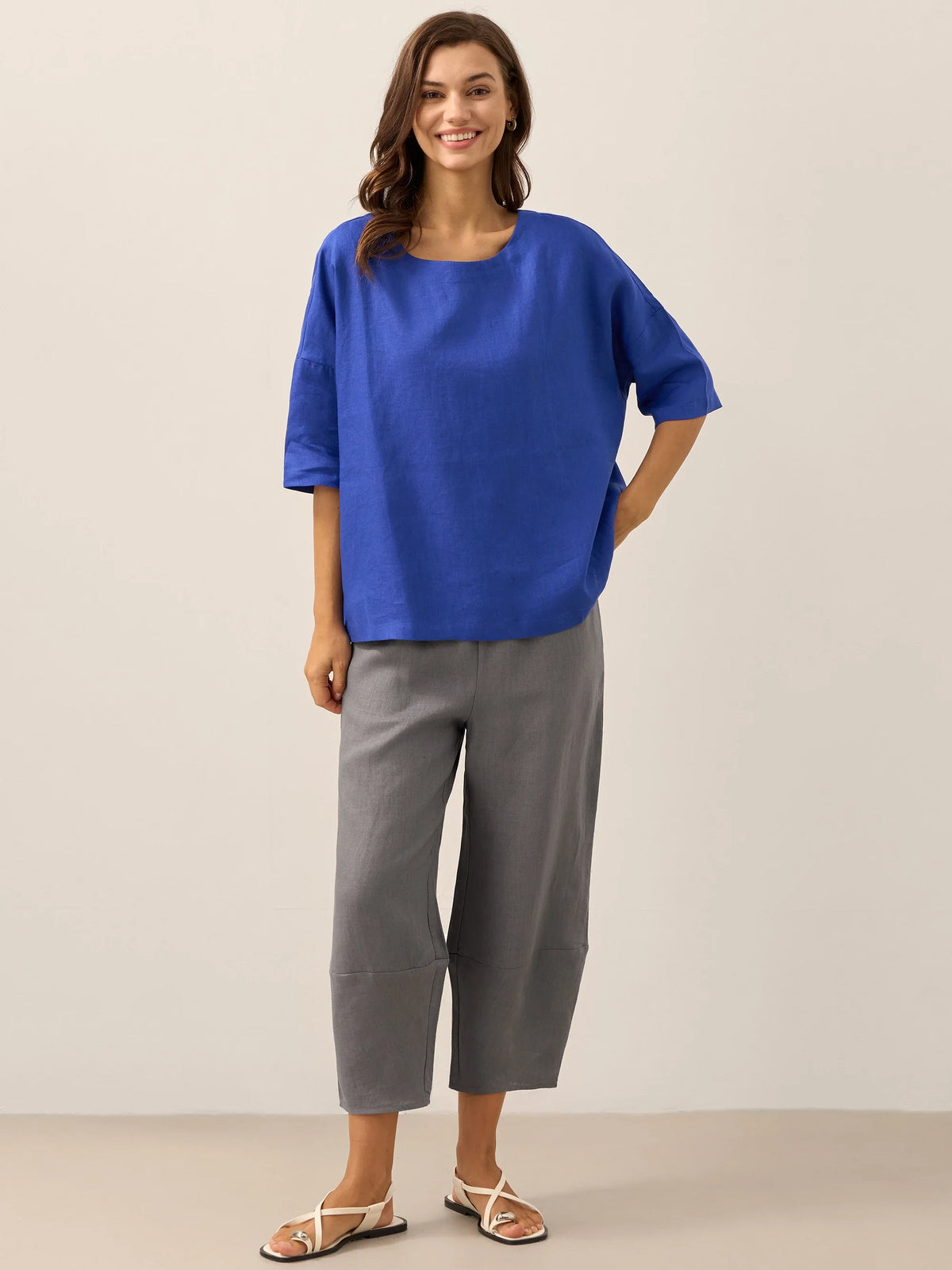 a woman in blue shirt and grey pants