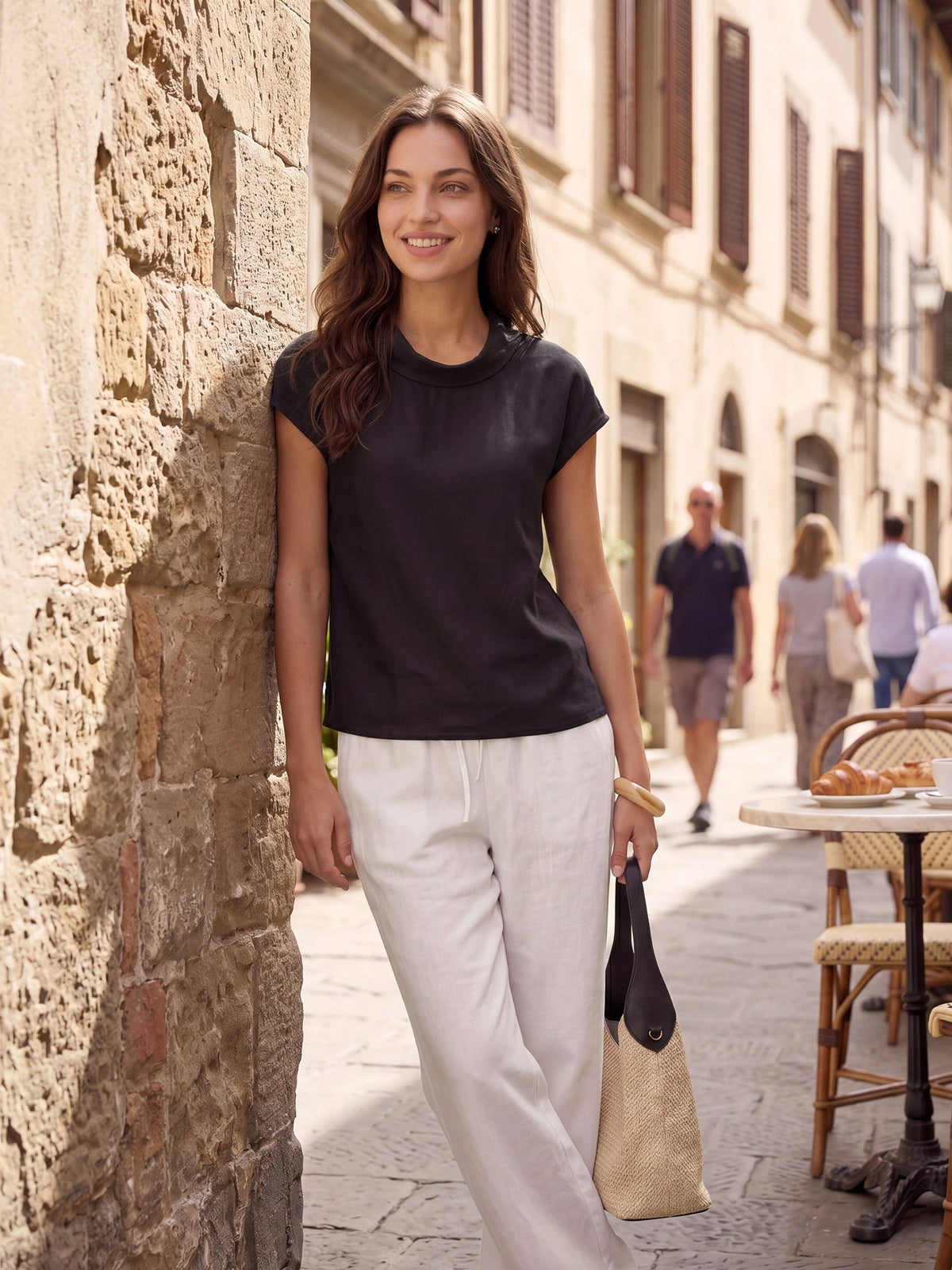 a woman standing next to a stone wall