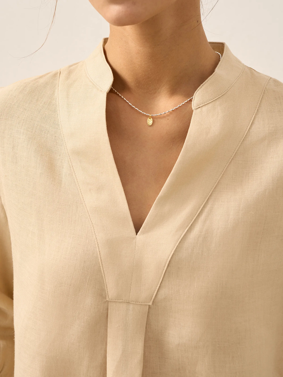 a woman wearing a gold necklace