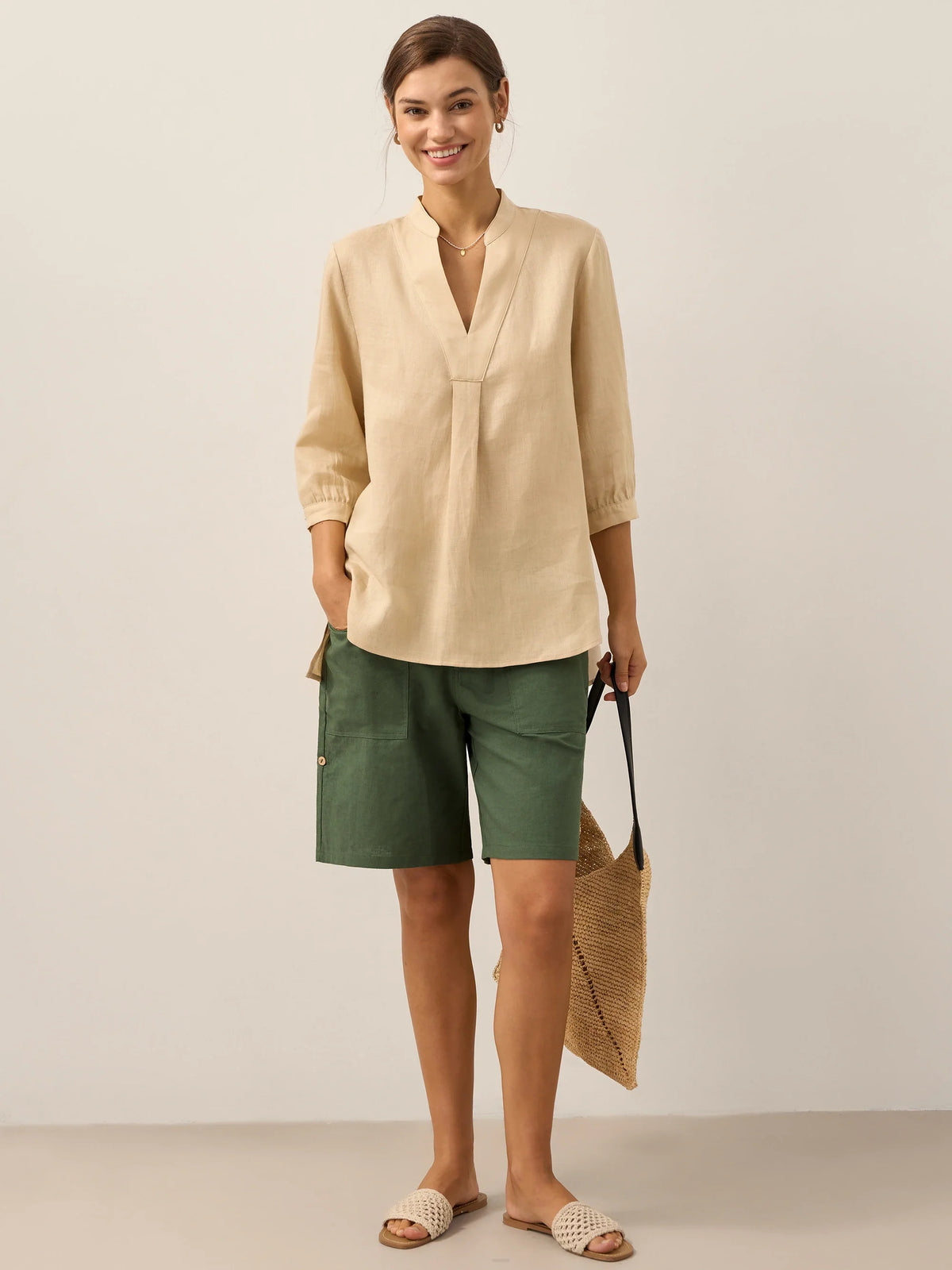 a woman in a beige shirt and green shorts