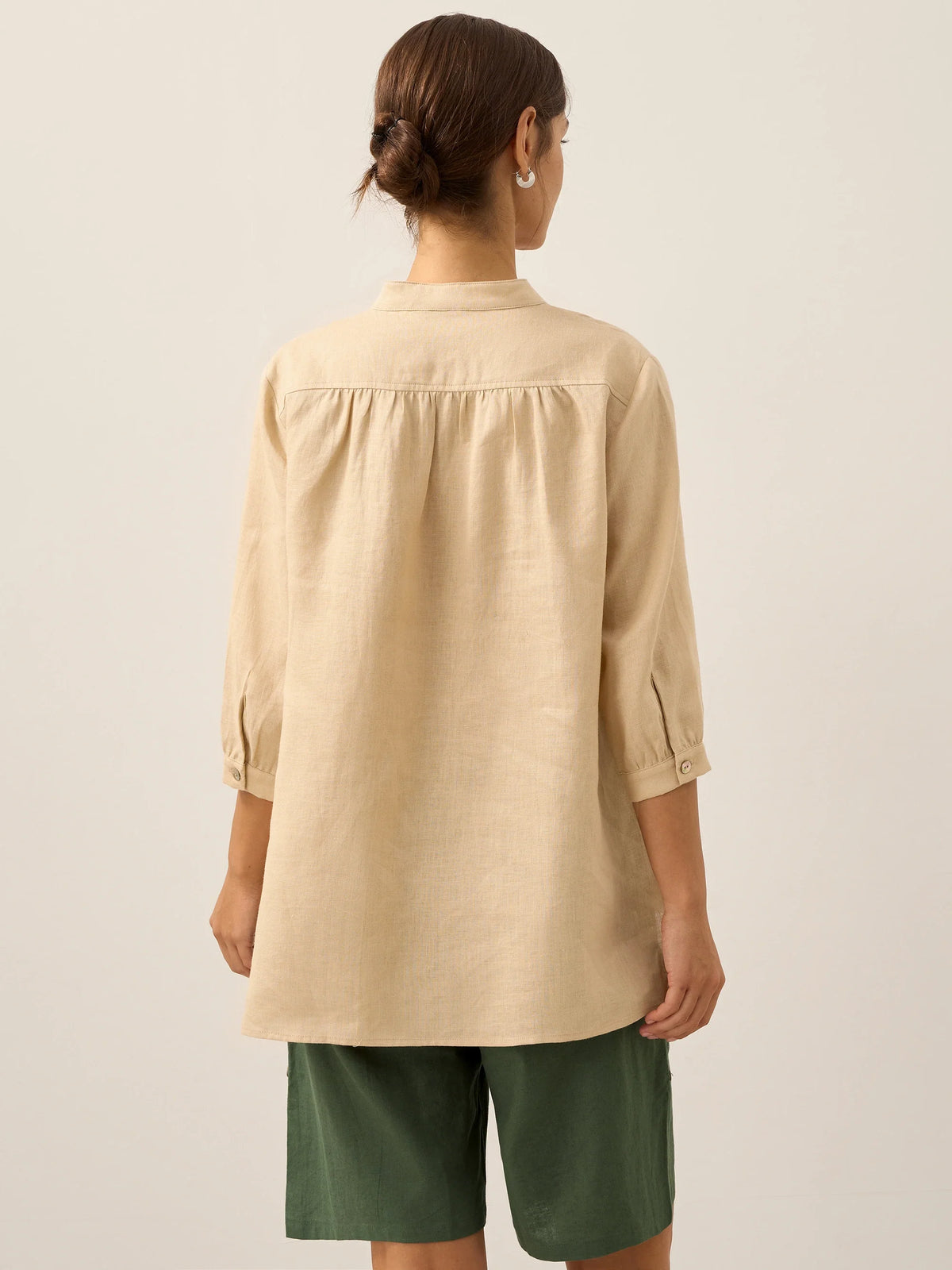 a woman in a beige shirt