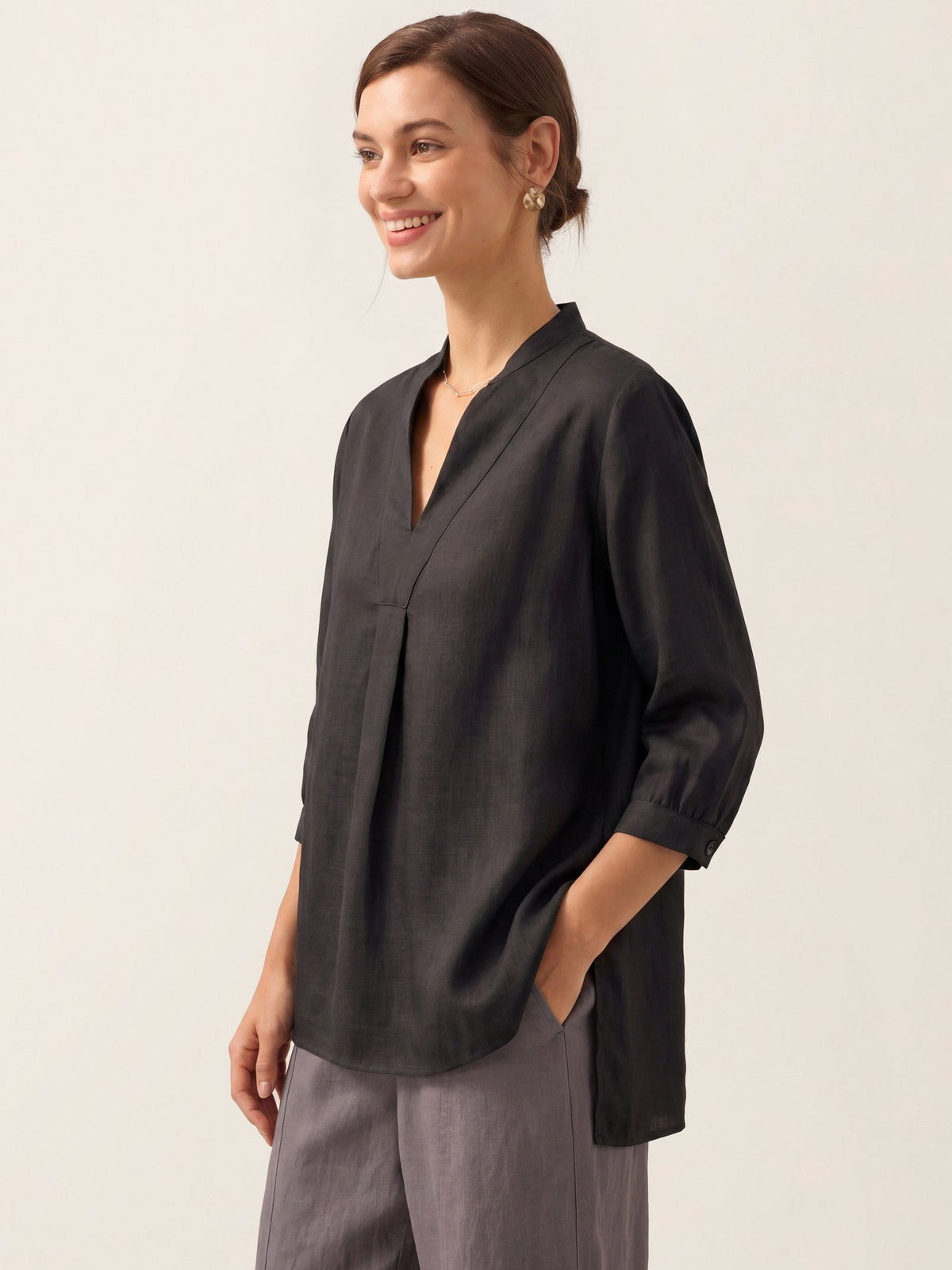 a woman smiling with her hand in her pocket