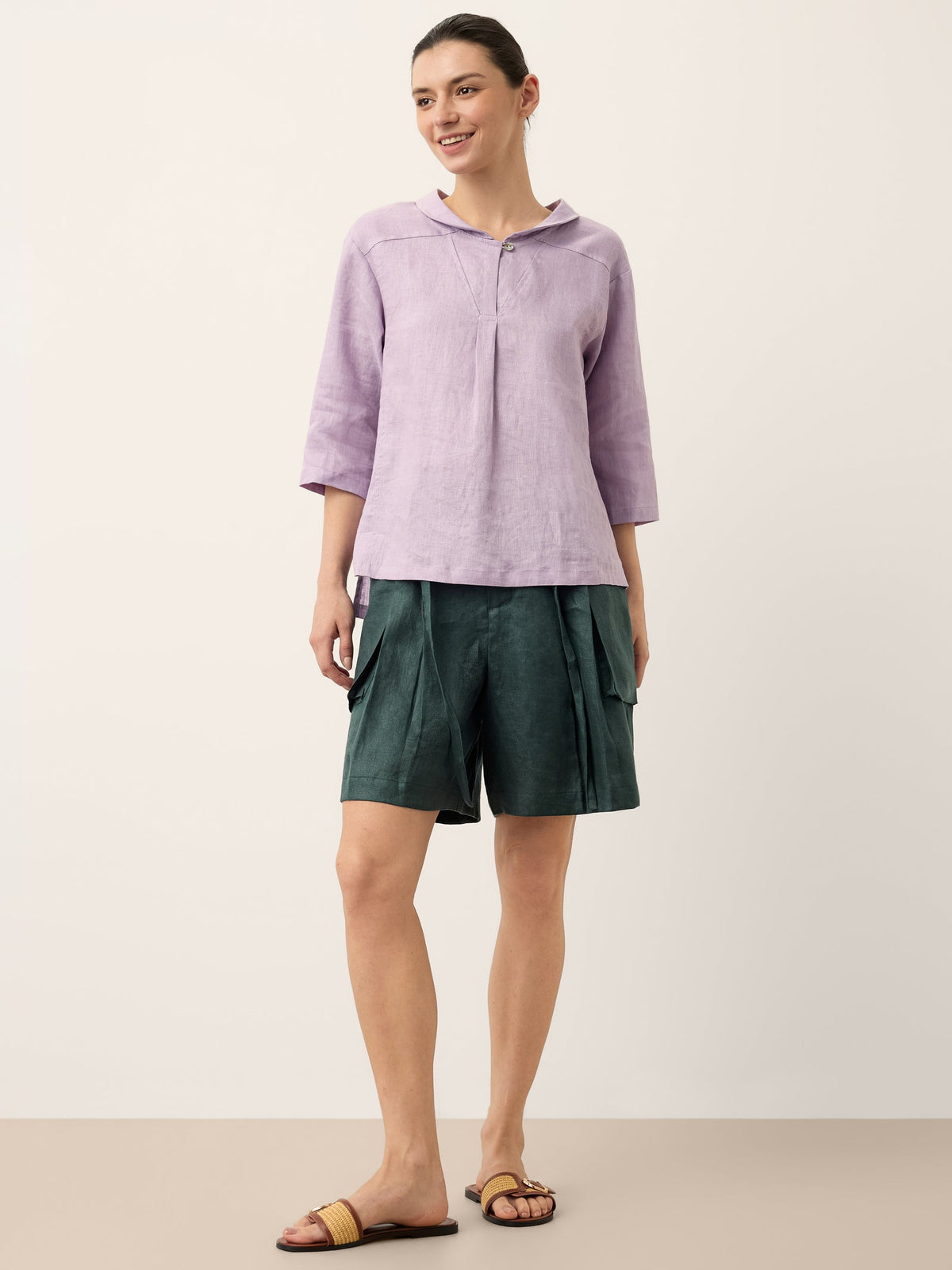 a woman in a purple shirt and green shorts