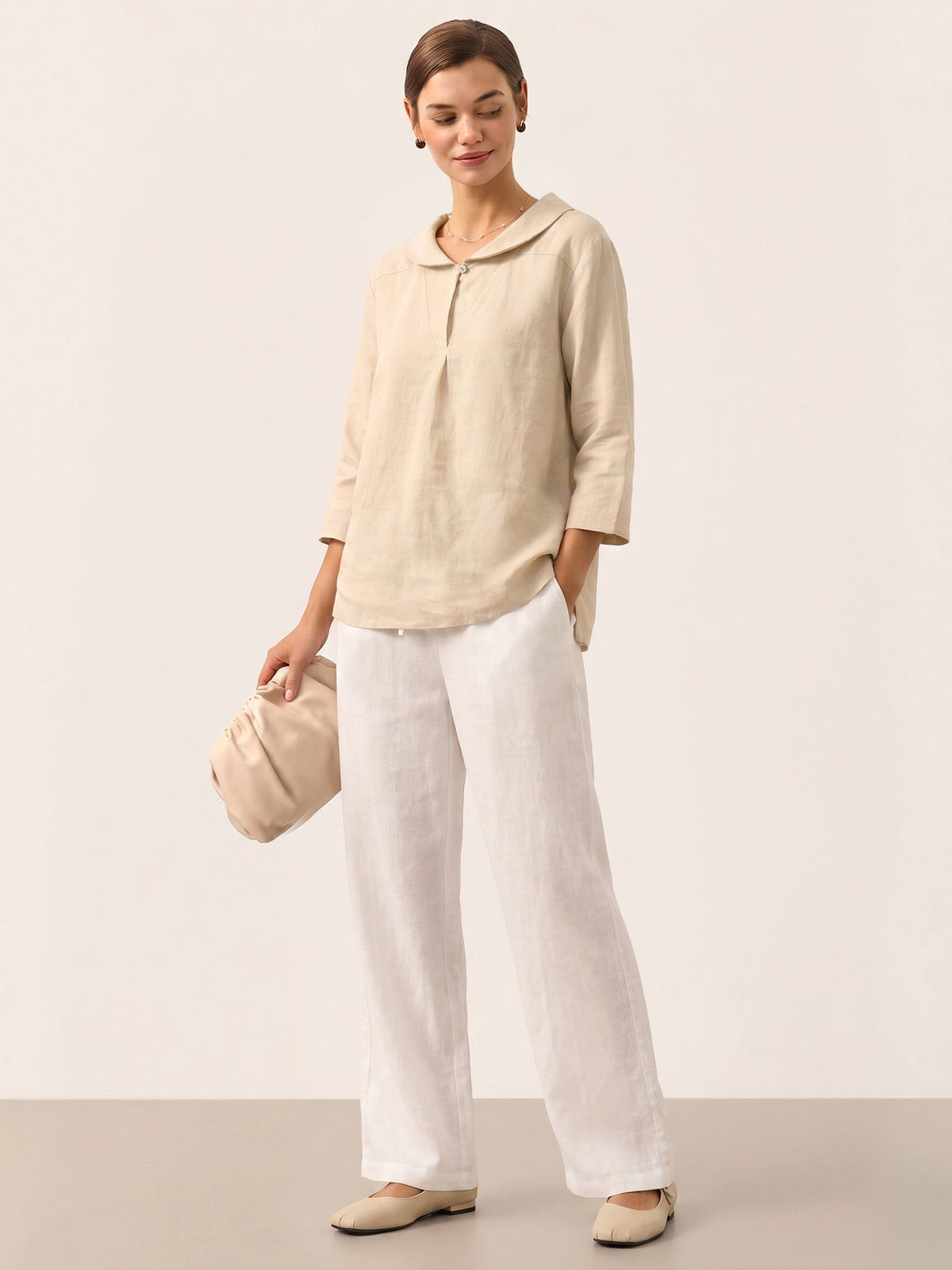 a woman in white pants and a beige shirt