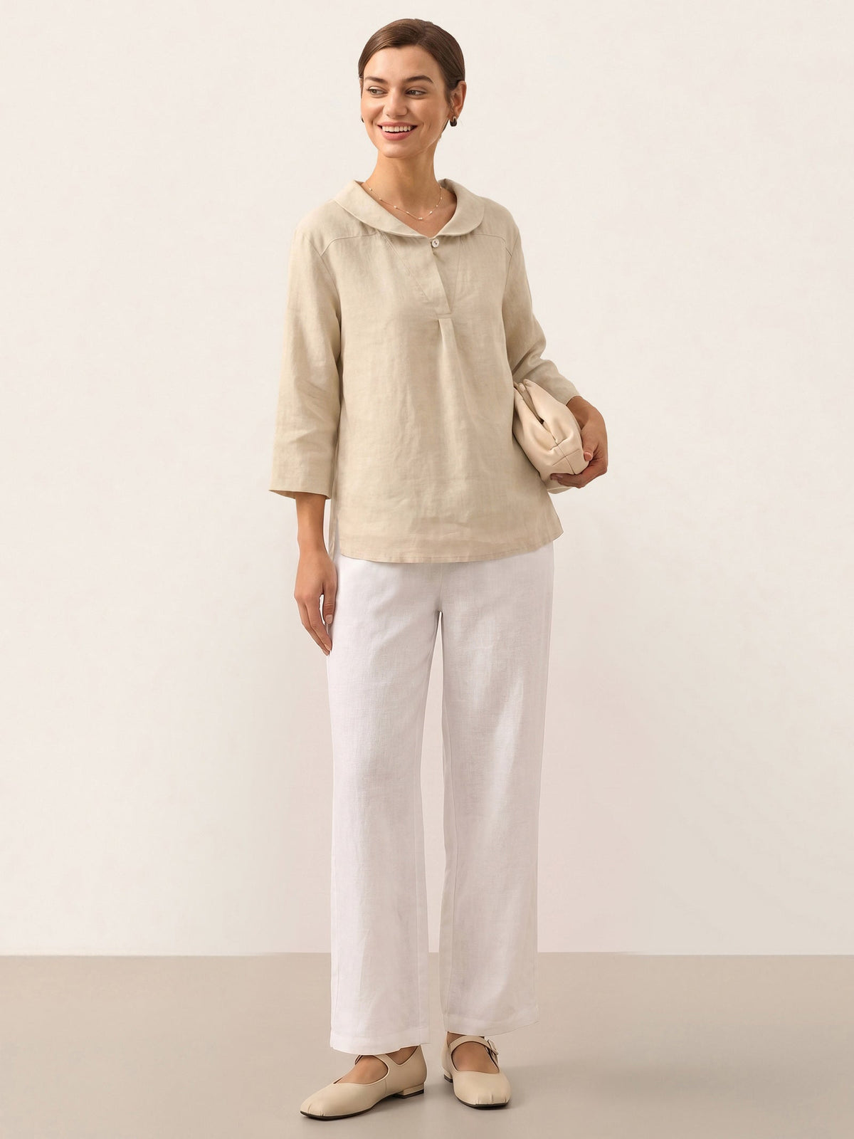 a woman in white pants and a beige shirt