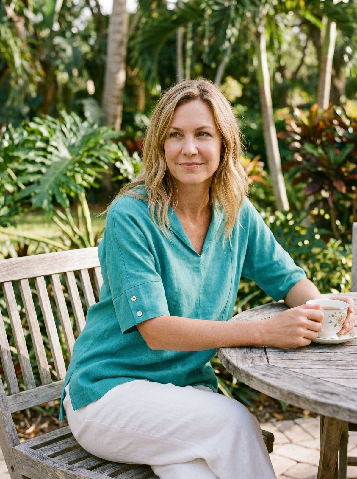 a woman sitting at a table with a cup of coffee
