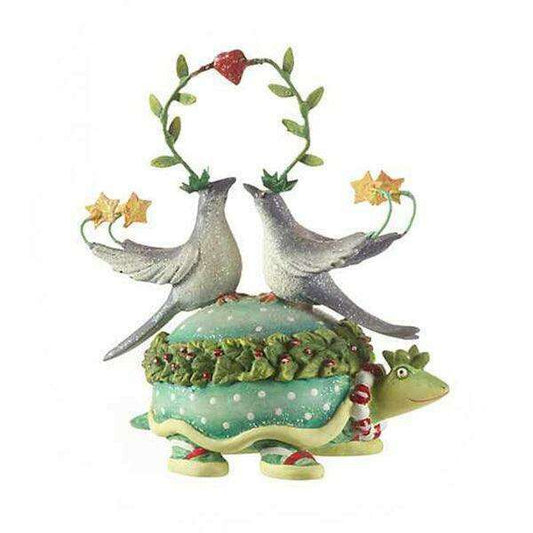 a statue of a turtle with birds on top