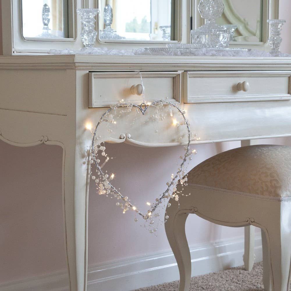 a white vanity with a heart shaped string of lights