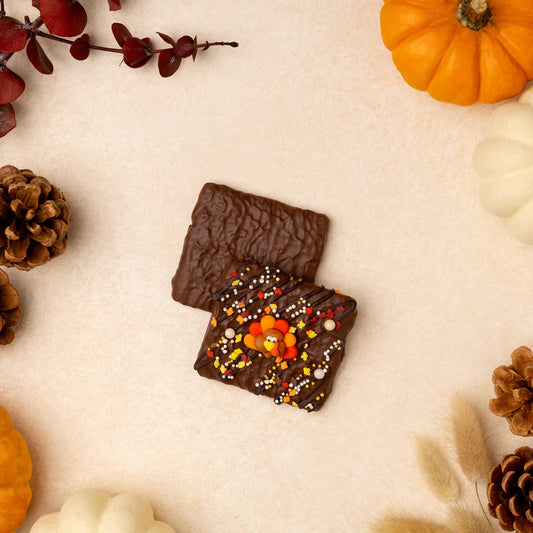 a chocolate and candy next to pumpkins and pine cones