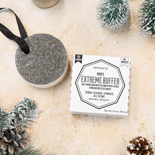 a box of men's extreme buffer next to a round object with pine cones