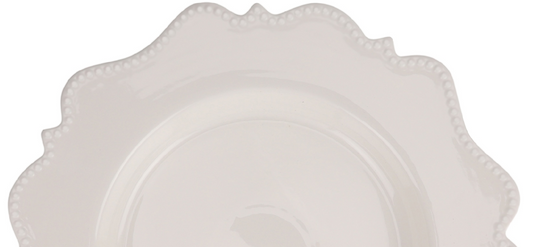 a white plate with a scalloped edge