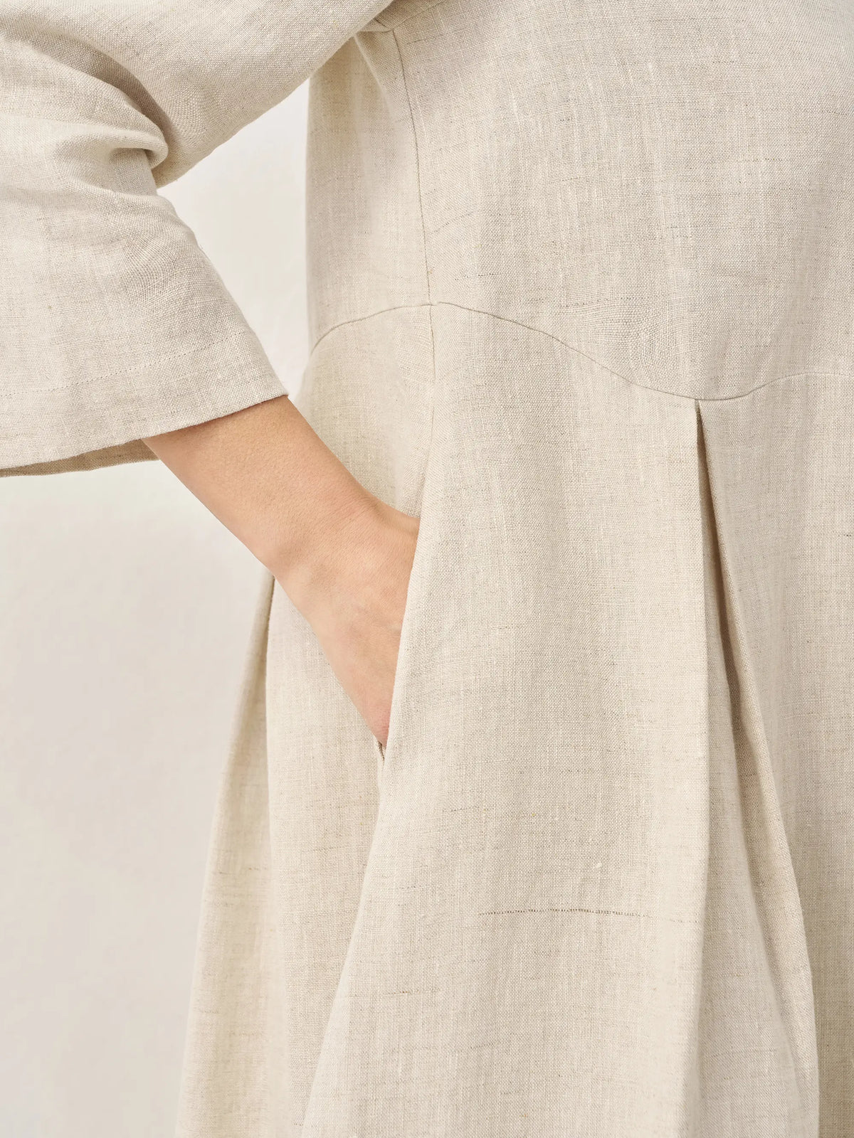 a close up of a woman's hand in a dress pocket