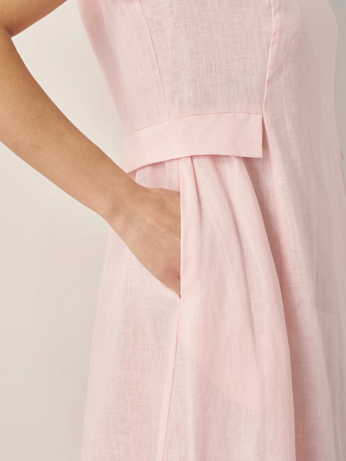 a close up of a woman's hand in a pink dress