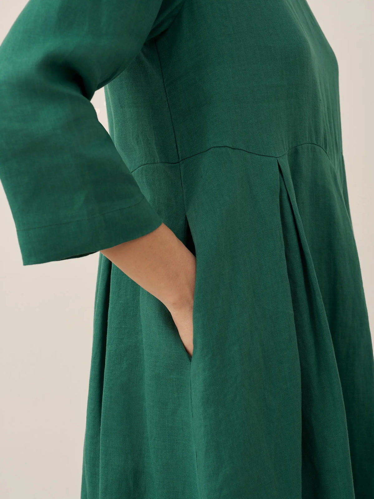 a close up of a woman's hand in a green dress