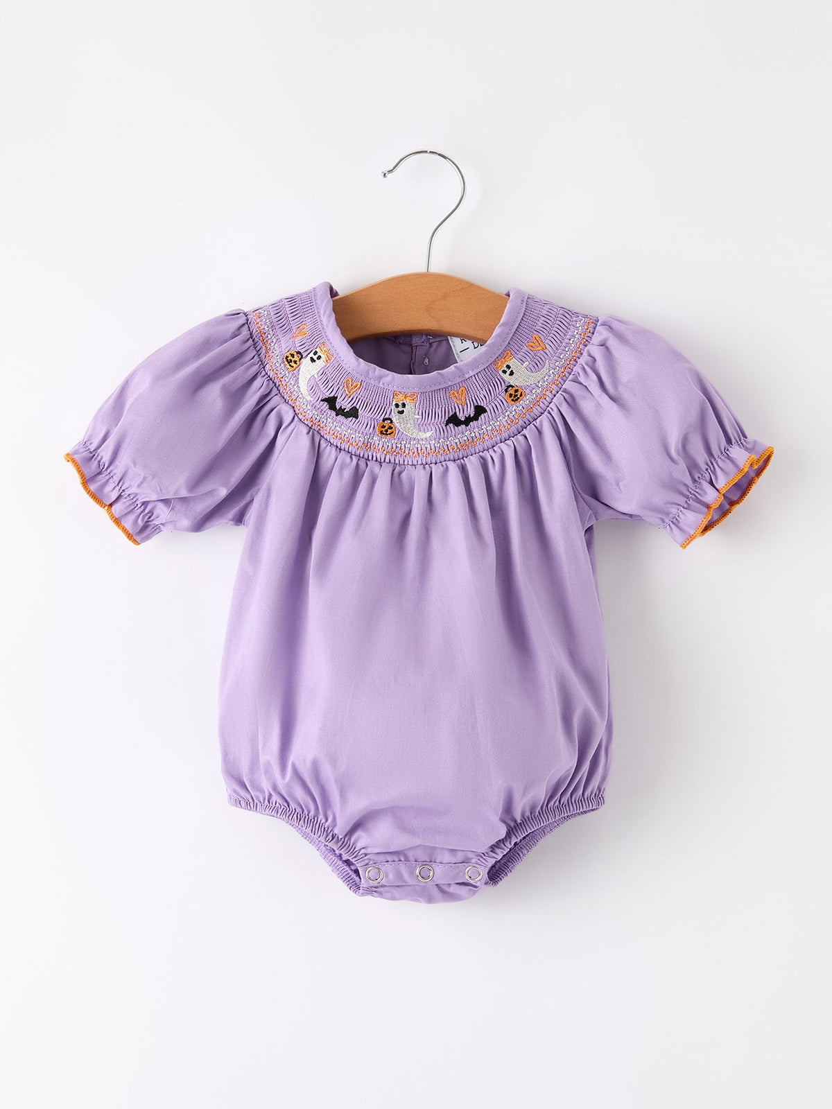 a purple baby romper on a swinger
