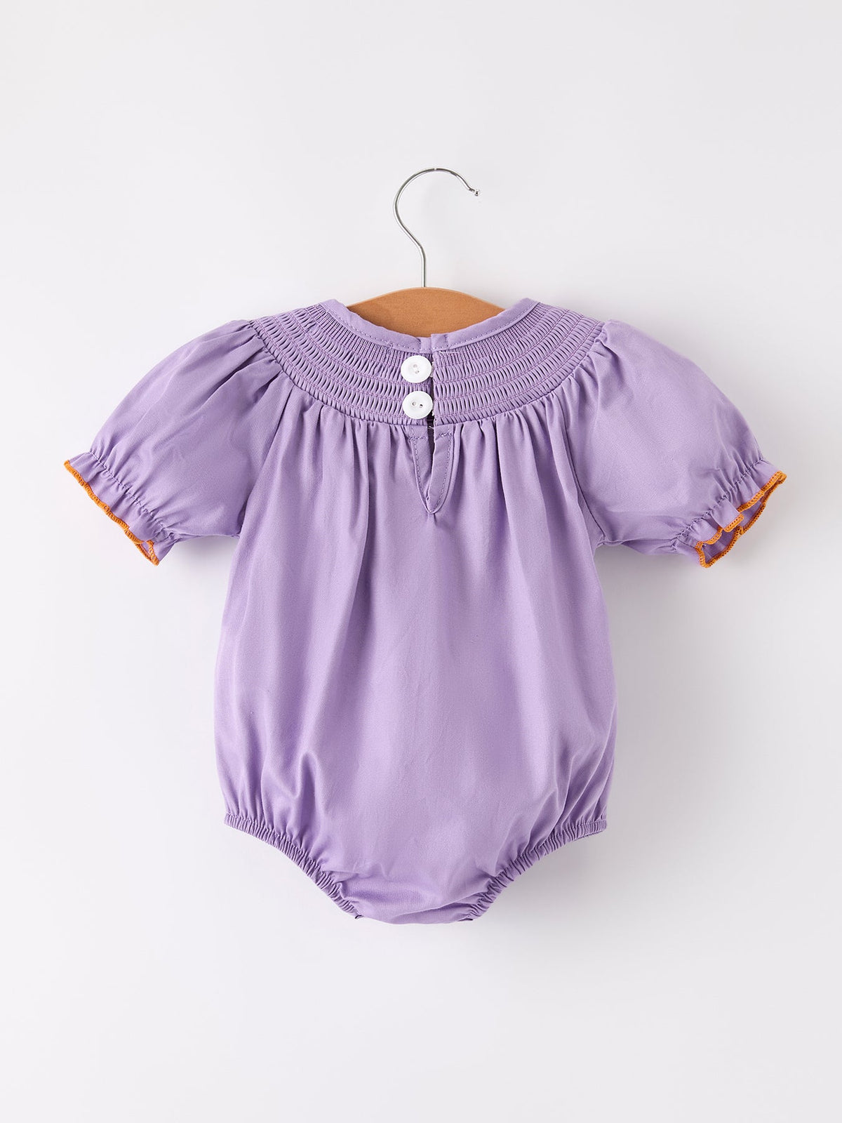 a purple baby romper on a swinger
